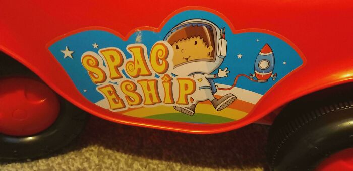 Close-up of a toy car with a sticker featuring an astronaut and the word SPACEHIP, a clear design fail.
