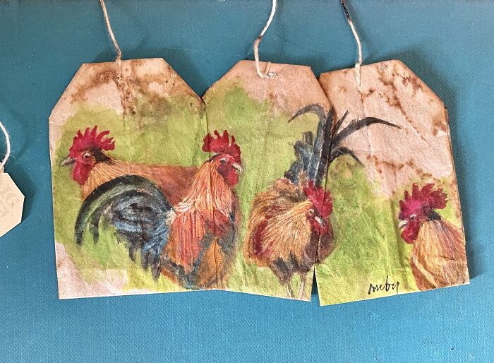 Miniature paintings of colorful roosters on used tea bags by artist Ruby Silvious