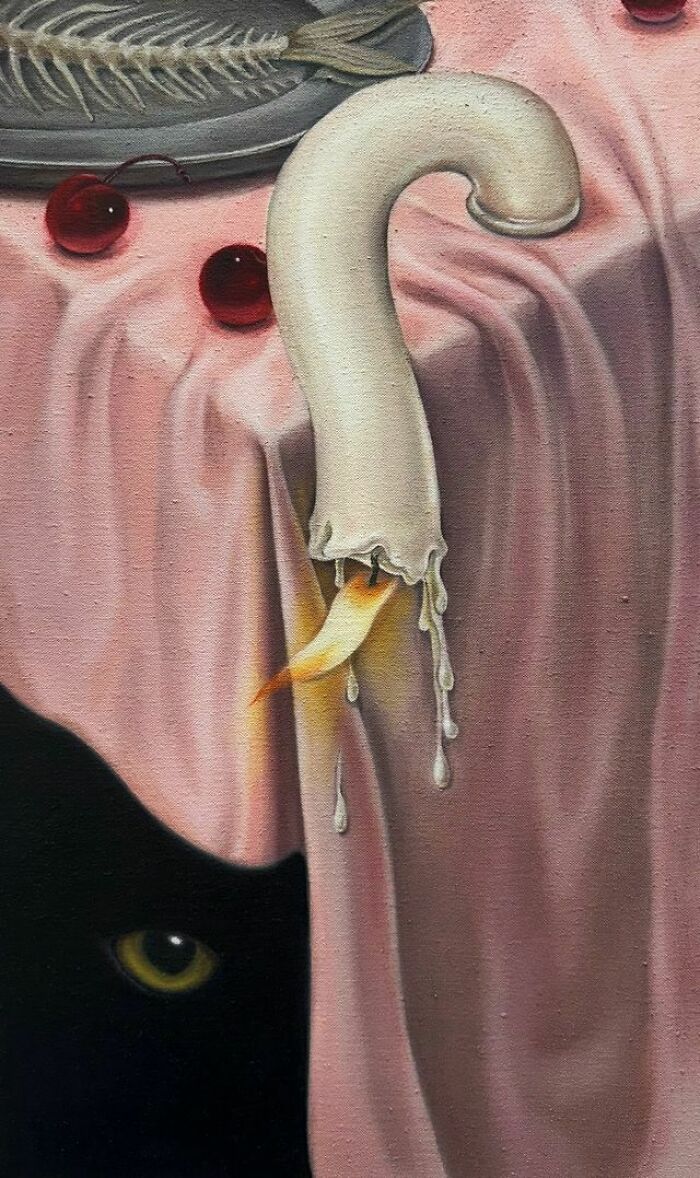 A surreal moment with a black cat peeking from beneath a pink tablecloth, beside a dripping candle, fish bones, and cherries.