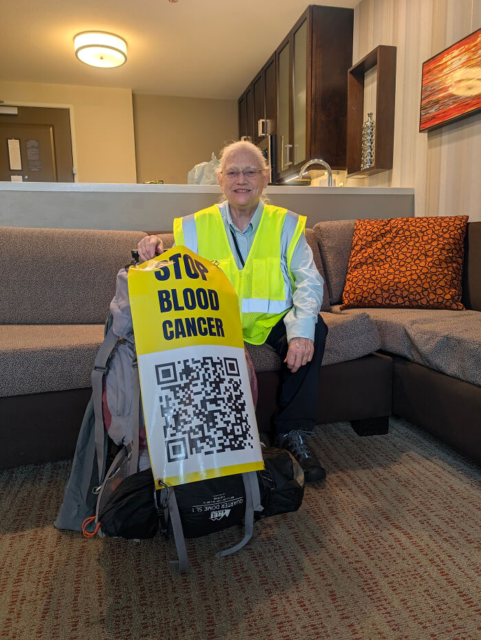 Woman in safety vest with backpack displaying stop blood cancer sign