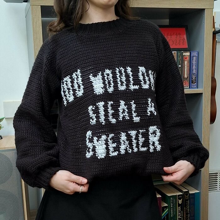 Black crochet sweater with white text highlighting creative crocheters' designs