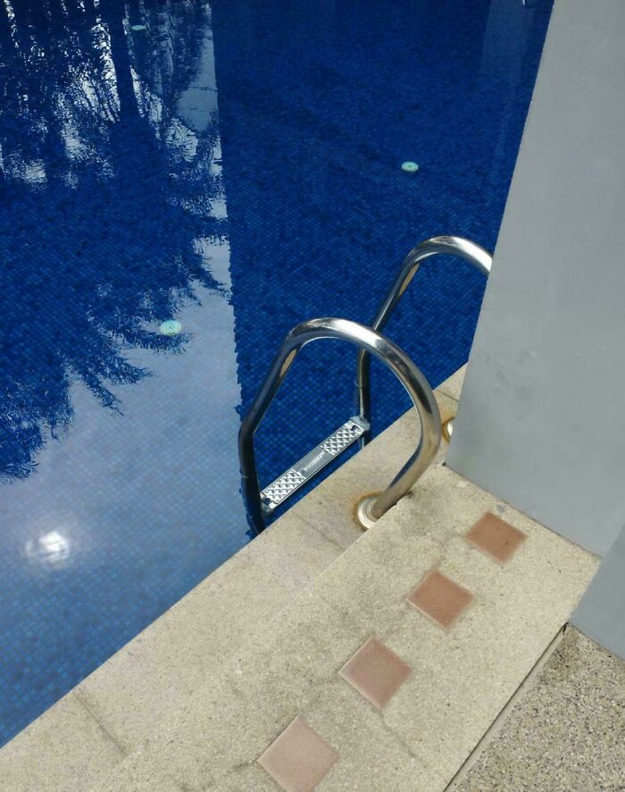 A swimming pool with an awkwardly placed ladder, highlighting a common design fail.