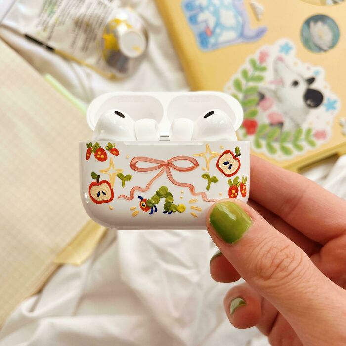Decorated earbuds case with caterpillar and apple design