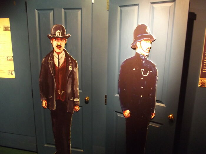 Two cutout figures of policemen standing in front of blue doors. Safety tips for women living alone to protect themselves.