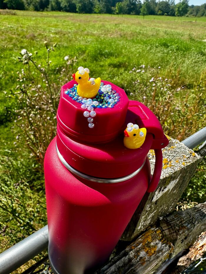 Red water bottle decorated with yellow duck charms and beads for quirky projects