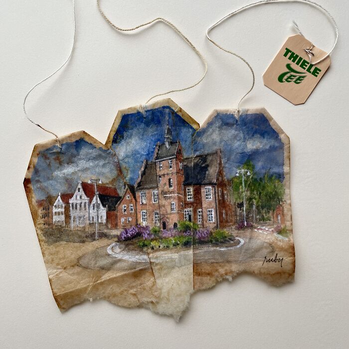 Delicate miniature paintings of historic brick buildings spanning across three used tea bags