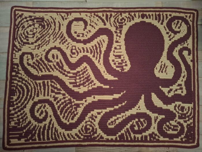 Crocheted octopus blanket showing detailed yarn work in maroon and beige colors