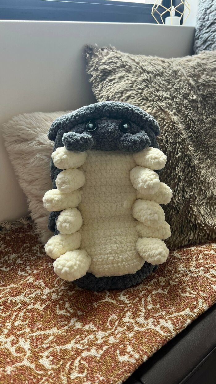 Soft crocheted plush toy resembling a grey and cream creature