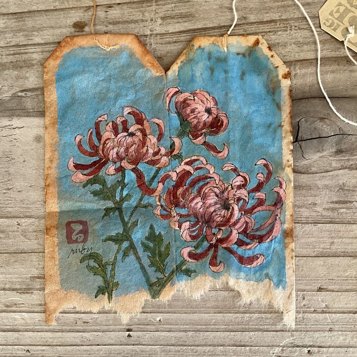 Pink chrysanthemum flowers painted on used tea bags as delicate miniature paintings