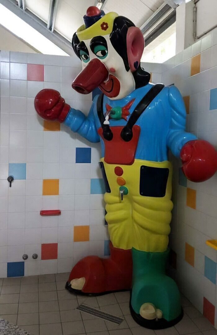 A truly bizarre, giant clown statue in a tiled room, making one wonder if they are hallucinating.