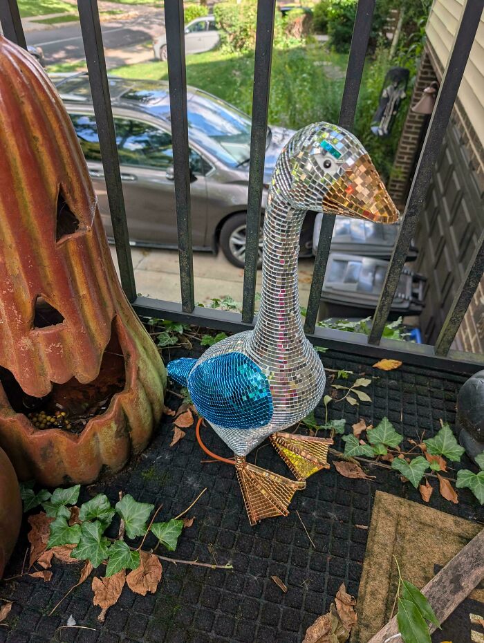 Disco goose sculpture made of mirrored tiles on outdoor mat
