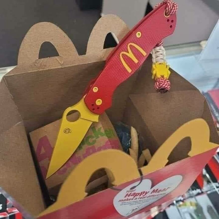 An uncomfortable and disturbing pic of a red and yellow McDonald's branded knife inside a Happy Meal box.