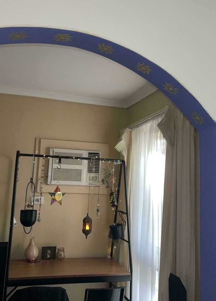 Quirky hanging decorations on a desk with air conditioner and sunlight through curtains