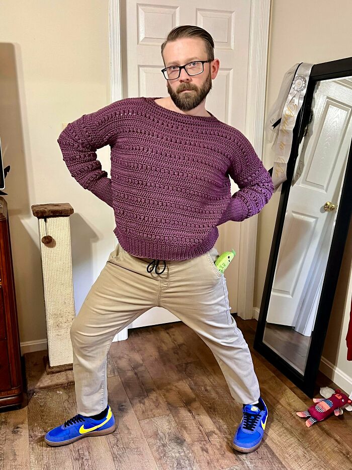 Man wearing a handmade purple crocheted sweater indoors
