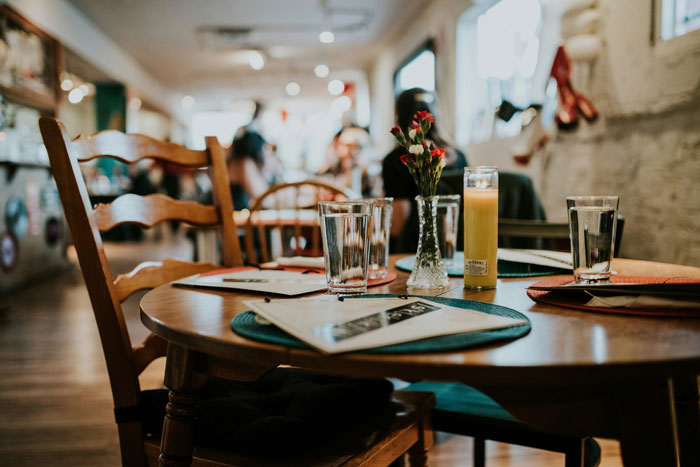 Cozy cafe table with glasses and menus in softly lit restaurant