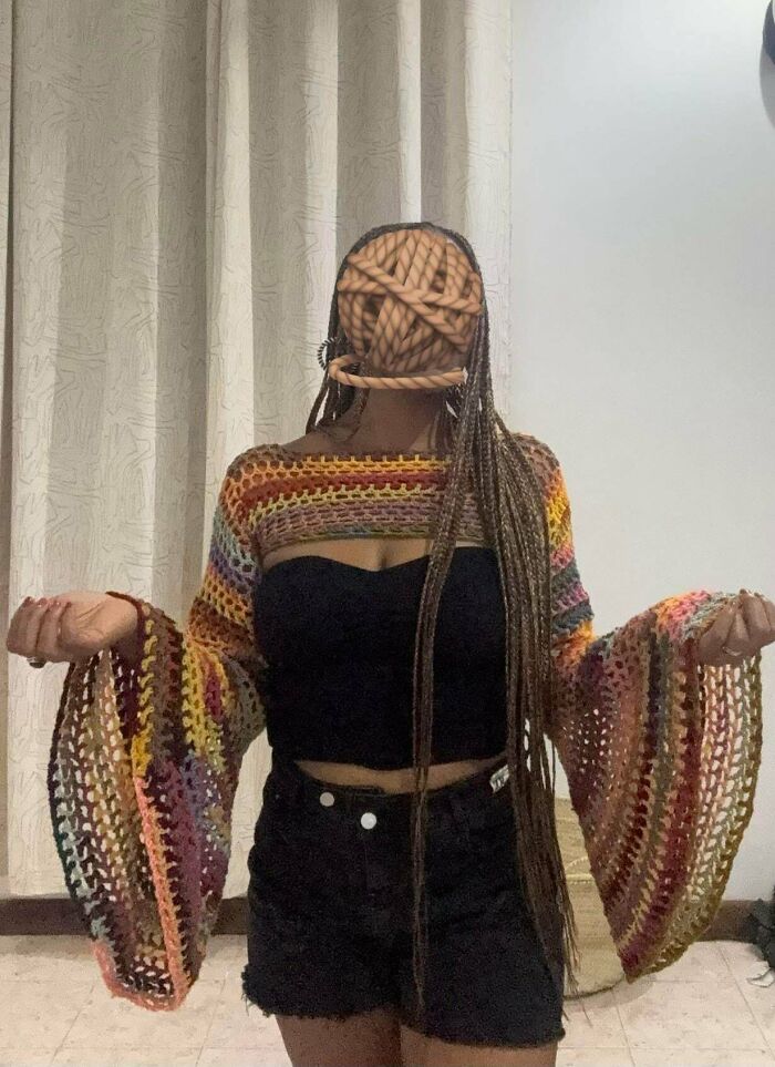 Person wearing colorful crocheted shrug with flared sleeves