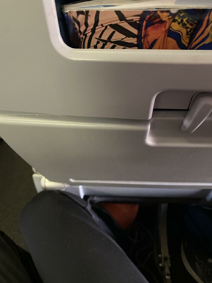 Entitled people on a plane; a passenger's foot is seen below the seat, needing a reality check.