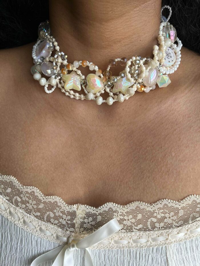 Iridescent beaded necklace with star and heart shapes on woman's neck