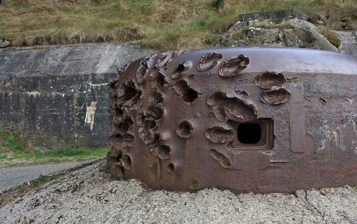 An old, rusty, and bullet-ridden forbidden foods bunker with a small opening.