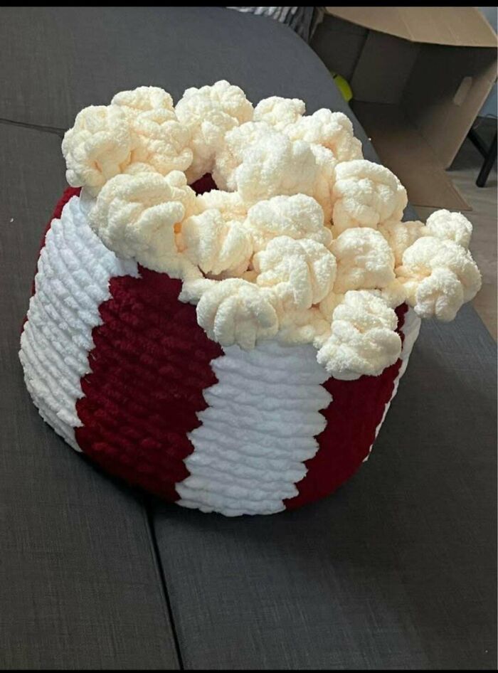 Crocheted popcorn bucket with white popcorn details on striped base