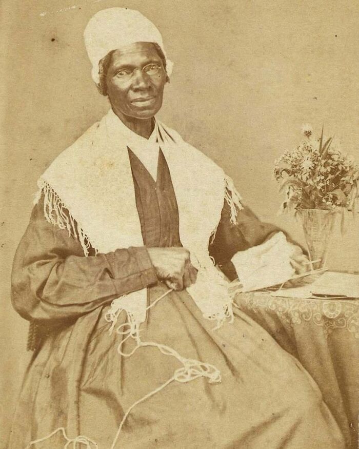 A sepia-toned portrait of a seated Sojourner Truth, an influential figure among Women In History, holding yarn.