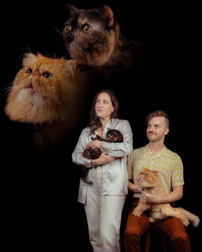 Quirky portraits of pets and their owners: A couple posing with their cats against a black background.