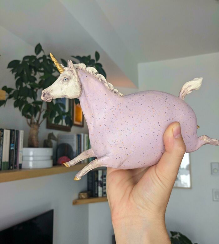 Hand holding a light purple ceramic unicorn figurine representing creative pottery creations.