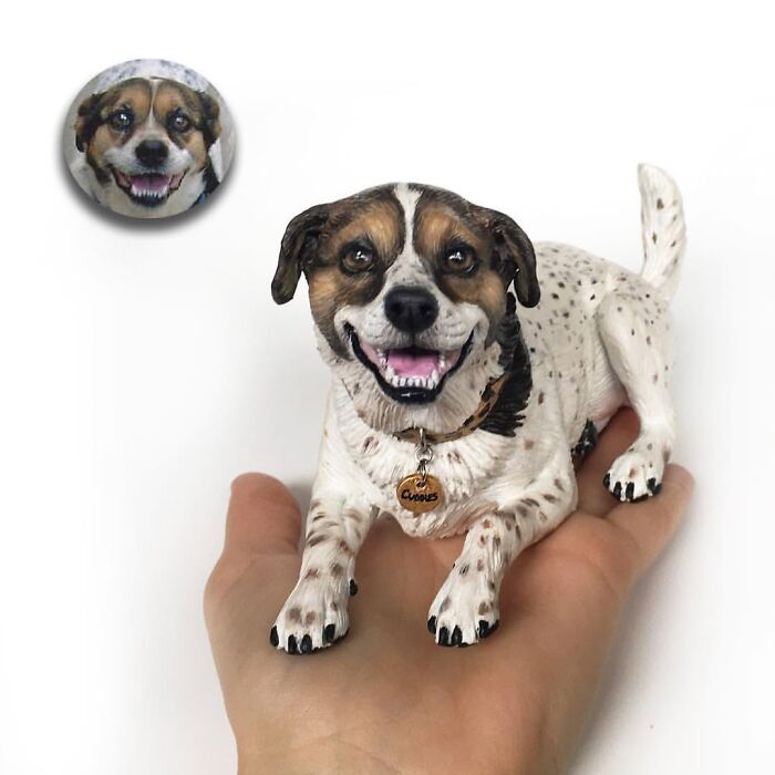 A happy, smiling dog figure resting in a hand, an example of hyperrealistic sculptures of pets made from photos.