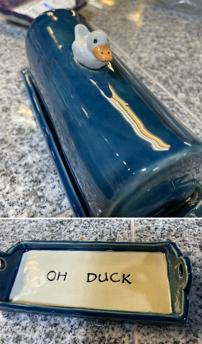 Blue pottery butter dish with a duck lid and text inside