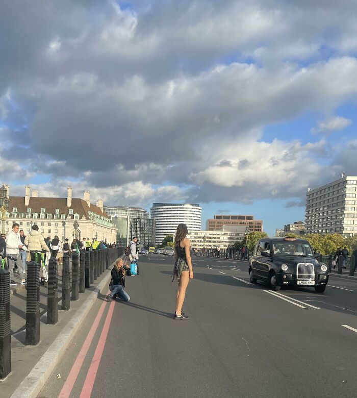 Woman influencers blocking traffic in public spaces for a photoshoot with a photographer on a bridge.