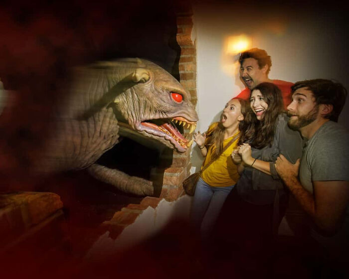 Group of frightened friends reacting to a giant monster creature in a haunted house photo