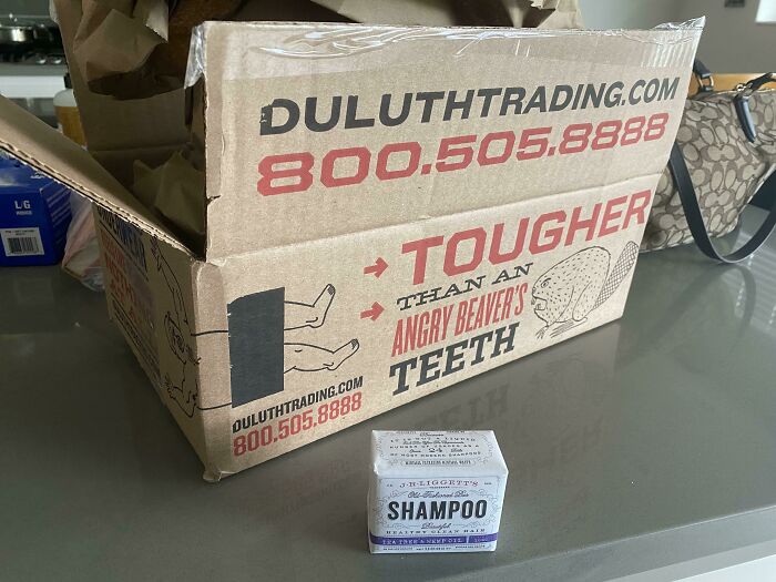 A tiny bar of shampoo sitting next to a huge shipping box, highlighting oversized packaging fails.