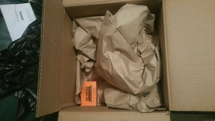 Small orange item in a huge box filled with brown paper as an example of bad packaging fails.