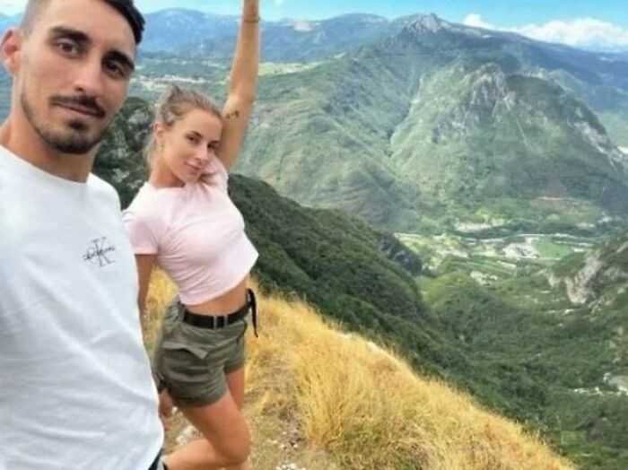 A couple captured in photos for the last time posing on a mountain ridge during a hike.