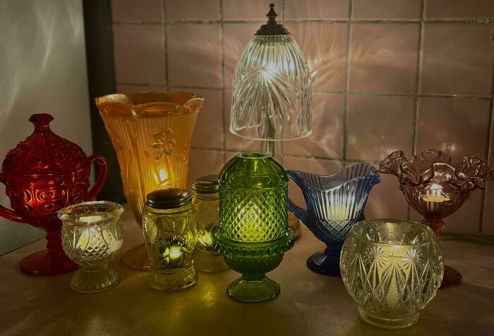 A collection of vintage colorful glass lamps and candle holders, a unique thrift store find.
