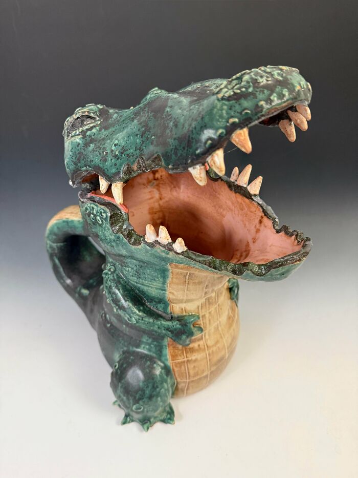 A hand sculpted green alligator mug showcasing unique pottery creations