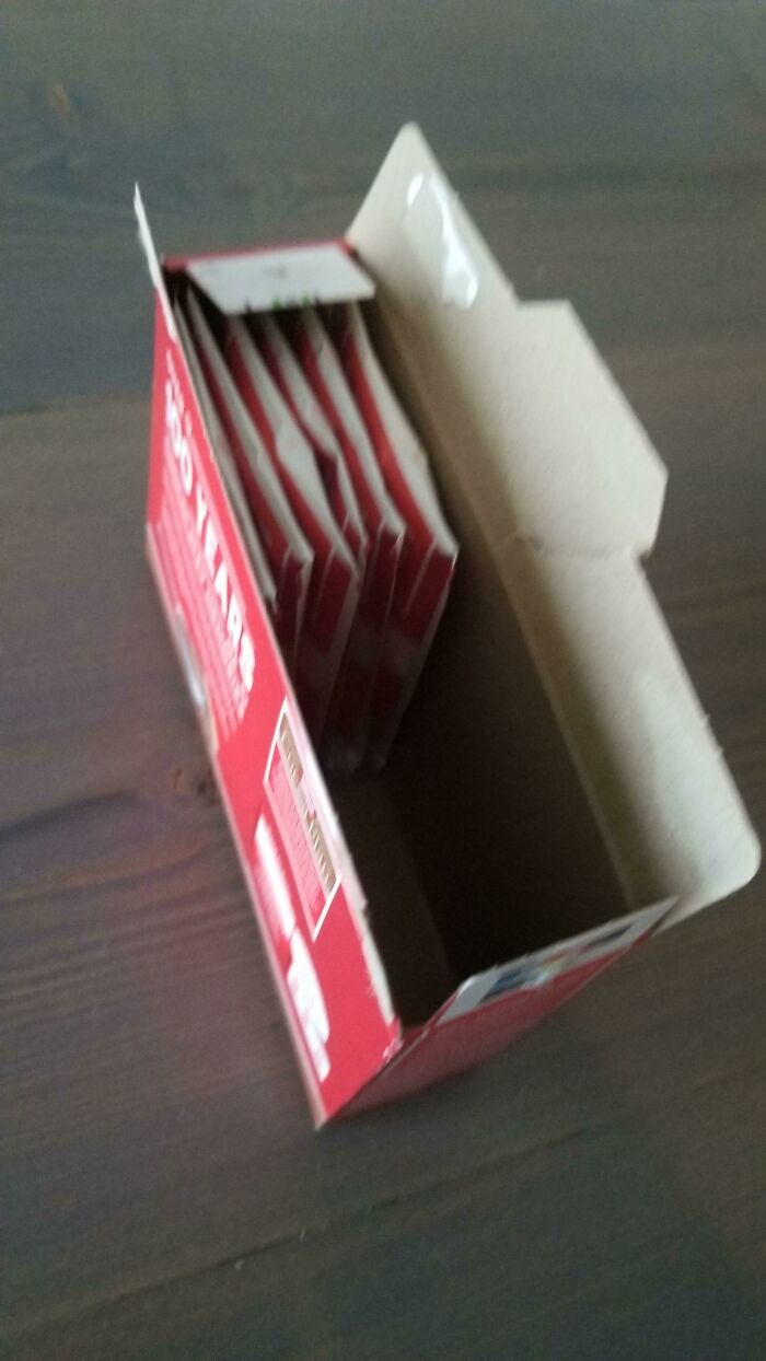 Cardboard box mostly empty with only a few thin packets demonstrating packaging fails