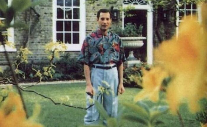 Freddie Mercury standing in a garden, captured in photos for the last time.