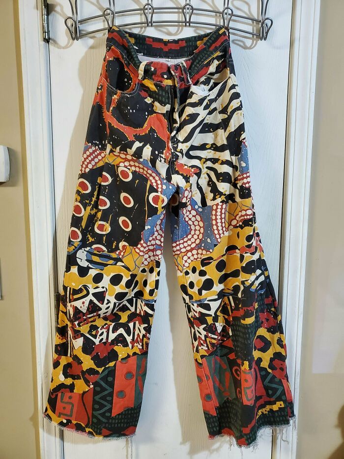Colorful patterned pants with abstract designs, a fun thrift store find hanging on a hanger.