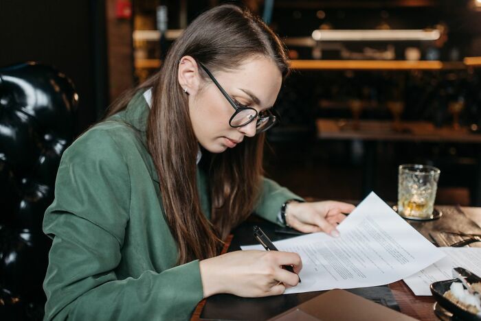 A woman reviewing legal documents, representing a potential reason marriages collapsed.