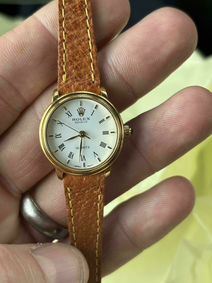 A hand holding a gold Rolex Geneve quartz watch, an amazing thrift store find.