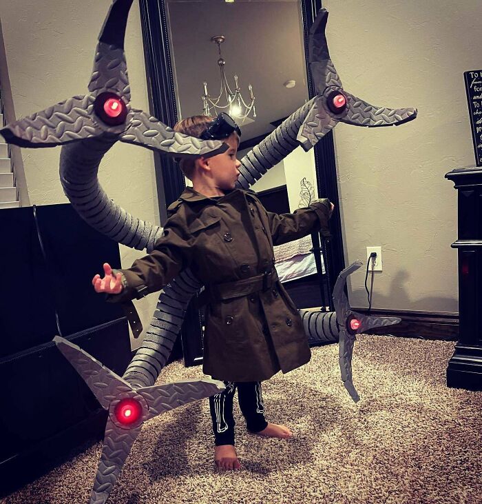 A young boy wearing an elaborate, homemade Doctor Octopus Halloween costume with mechanical tentacles.