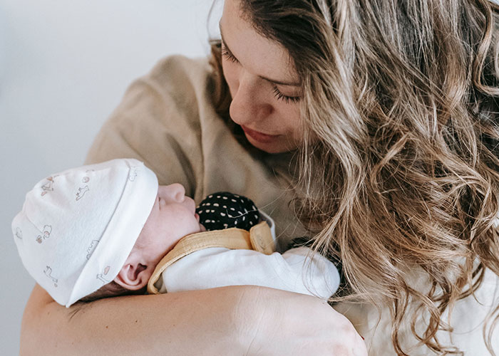 A mother lovingly holding her sleeping baby in her arms during new motherhood
