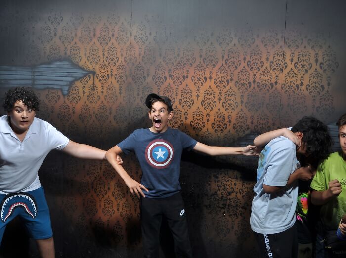 Scared boys reacting with hilarious faces in a haunted house photo.