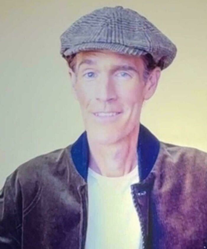 A man captured in photos for the last time wearing a flat cap and jacket smiling.