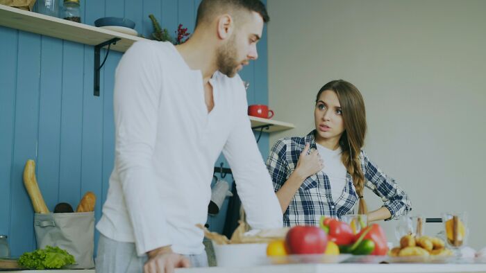 A frustrated couple argues in the kitchen, illustrating common reasons marriages collapsed.