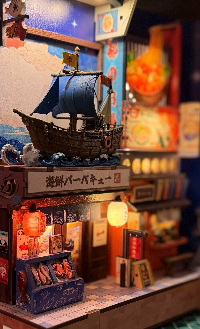 A Japanese street food stall styled miniature book nooks insert with a blue sailboat model