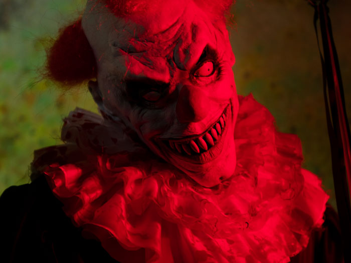 A terrifying evil clown bathed in red light, inspired by scary Halloween stories.