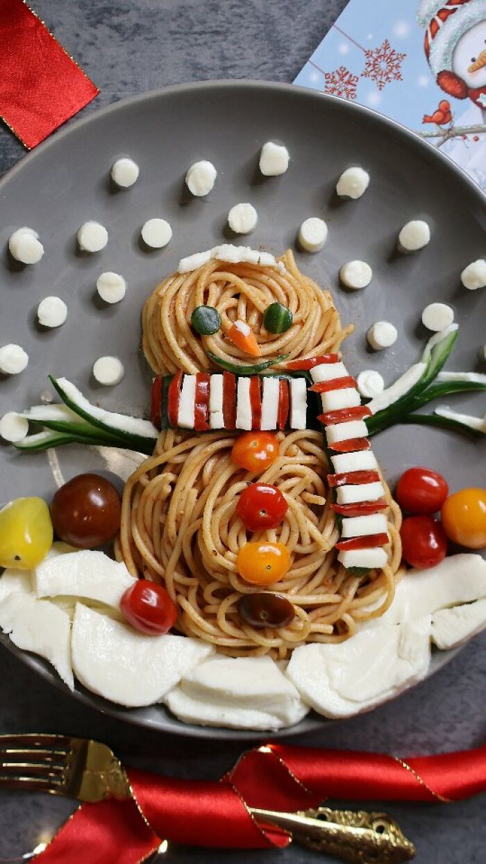 A snowman constructed using spaghetti and vegetables as a playful work of art.