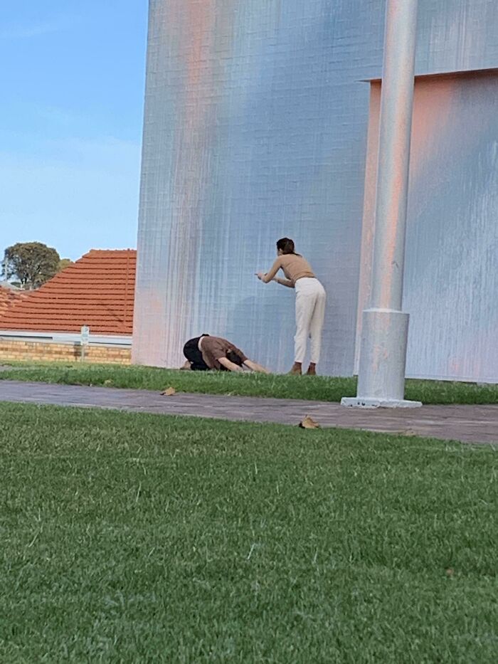 Influencers posing near a large modern wall treating public spaces as their personal content studio
